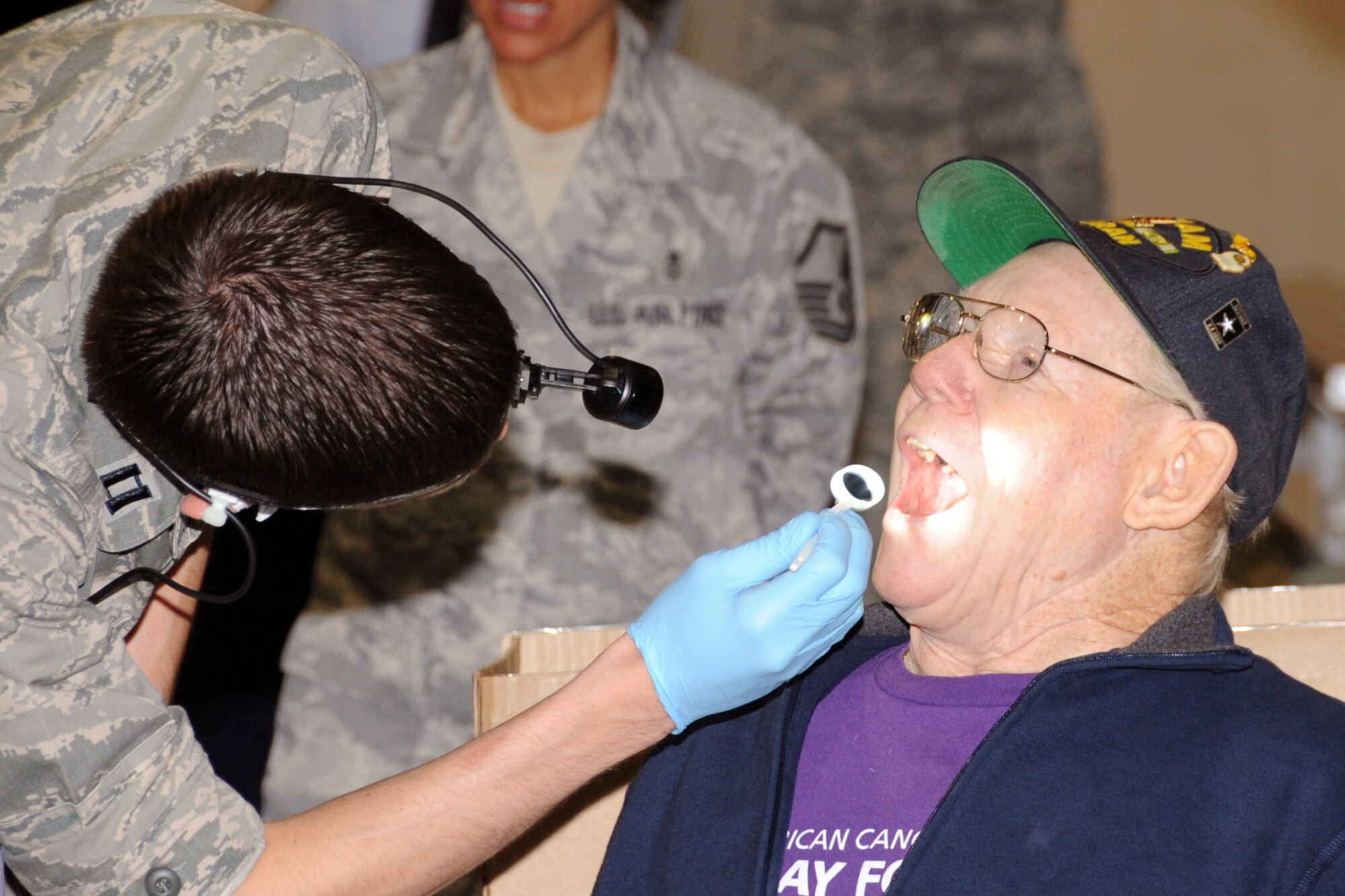 OFFUTT AIR FORCE BASE, Neb. - Capt. Scott Rohr, 55th Dental Squadron, provides an oral exam for Johann Schniedermeier, retired U.S. Army Staff Sgt. during Offutt's annual Retiree Appreciation Day, Oct. 17. The event was held at the Offutt Field House and offered retirees from the local area the opportunity to attend briefings and receive information about a variety of agencies including the Retiree Activities Office, Airman & Family Readiness Center, Department of Veteran Affairs, Survivor Benefits, the Erhling Bergquist medical clinic and Legal office ain addition to the dental care. U.S. Air Force photo by Kendra Williams