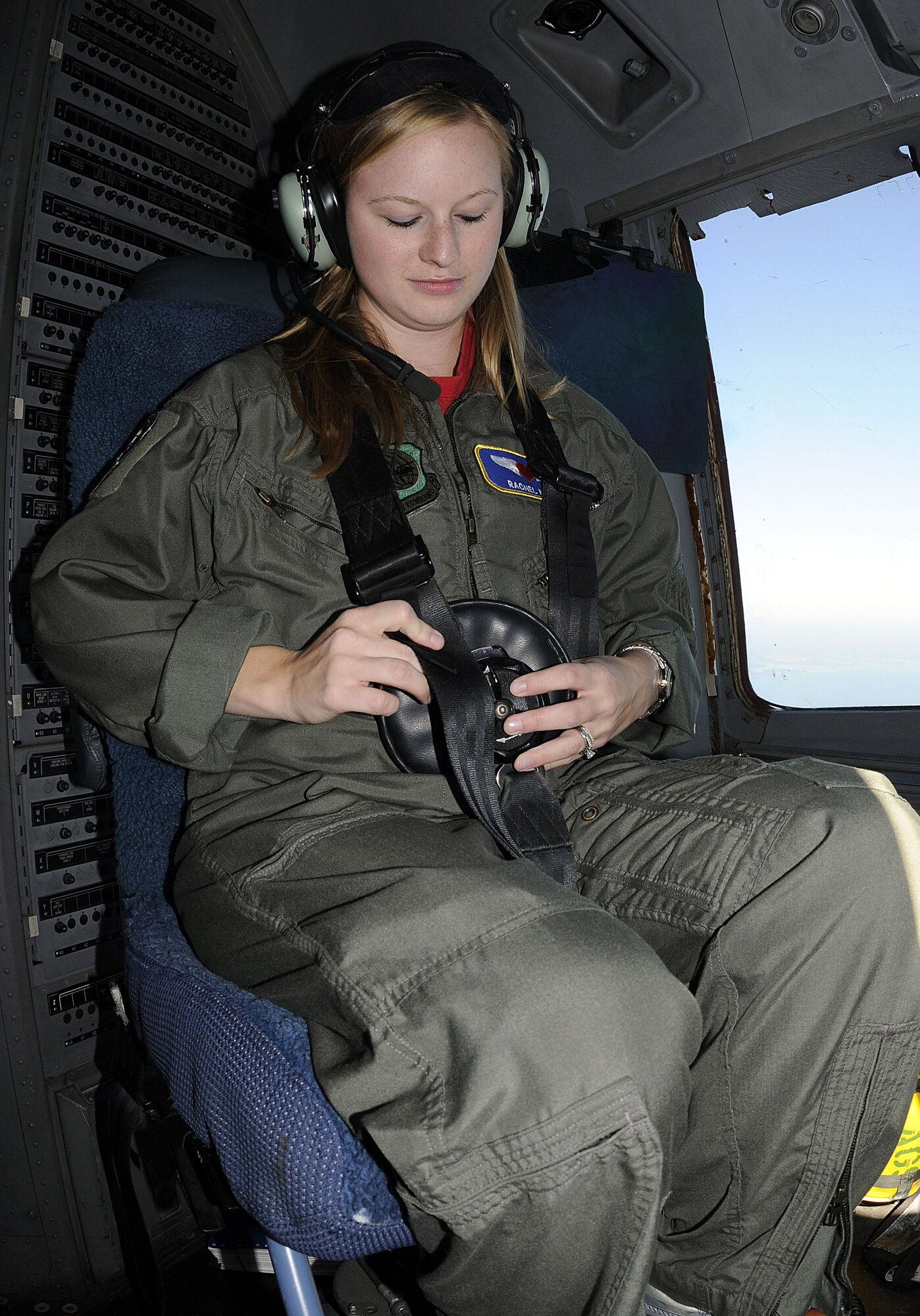 Rachel Kerr dons a safety harness in preparation for landing at Joint Base Charleston-Air Base after a spouse orientation flight onboard a Charleston C-17, Oct. 16. The orientation flight is a way to familiarize spouses with their military member?s job and help educate them on the Airlift mission. Mrs. Kerr is the wife of Capt. Rick Kerr, a member of the 16th Airlift Squadron. (U.S. Navy photo/Mass Communication Specialist 1st Class Jennifer Hudson)