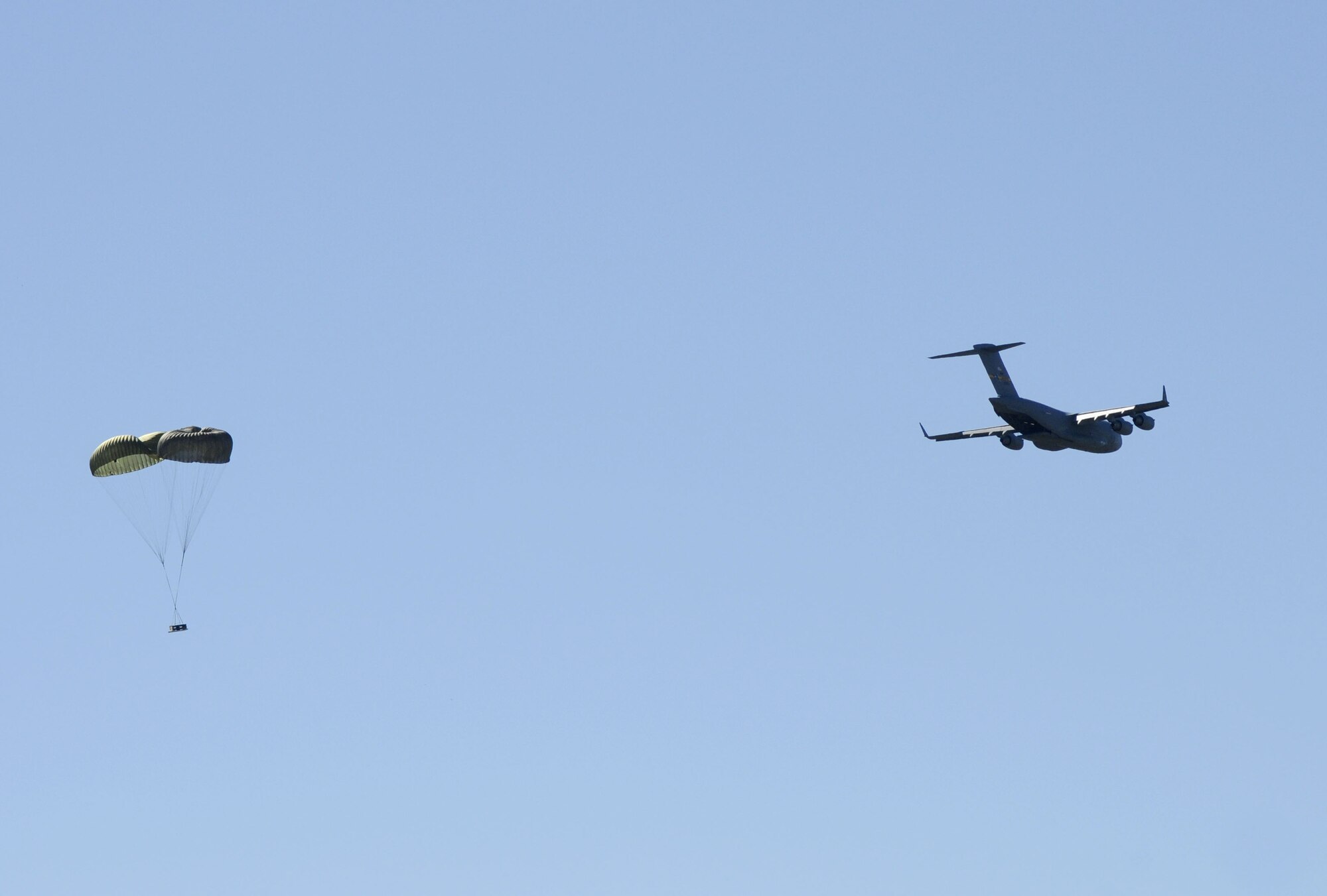 More than 60 spouses watched as two Charleston C-17 performed an airdrop training mission at North Field, Oct. 16. They conducted a heavy-air-drop and container delivery system-air-drop; dropping pallets and small containers from the cargo bay area of the plane. The wives were given the opportunity to take a flight from Joint Base Charleston-Air Base to the North training fields for routine training during a spouse orientation flight that helping to educate them on the airlift mission. (U.S. Navy photo/Mass Communication Specialist 1st Class Jennifer Hudson)