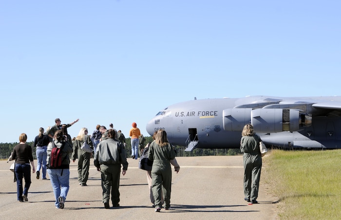 Spouses make their way back to a Charleston C-17 after watching the aircraft perform a routine air-drop training mission, Oct. 16. The wives were given the opportunity to take a flight from Joint Base Charleston-Air Base to the North training fields to observe a training mission during a spouse orientation flight that helped educate them on the airlift mission. (U.S. Navy photo/Mass Communication Specialist 1st Class Jennifer Hudson)