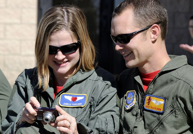 Janelle Yarolimek shows her husband, 1st Lt. Nate Yarolimek, photographs she had taken during a spouse orientation flight, Oct. 16. The event was held to integrate new members and spouses with the team and to familiarize them with their spouse?s job. Lieutenant Yarolimek is a member of the 16th Airlift Squadron. (U.S. Navy photo/Mass Communication Specialist 1st Class Jennifer Hudson)