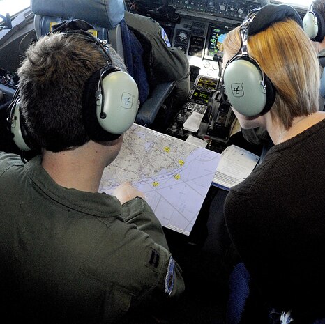 Capt. Justin Jarrell shows Chantil Stoddard on a map the area where the aircraft was flying during the spouse orientation flight, Oct. 16. More than 60 spouses were given the opportunity to learn what their spouse?s job entailed during a routine training mission flight onboard a Charleston C-17. Captain Jarrell is a pilot with the 17th Airlift Squadron and Mrs. Stoddard is the wife of the 1st Lt. Eric Stoddard, a pilot with the 15th Airlift Squadron. (U.S. Navy photo/Mass Communication Specialist 1st Class Jennifer Hudson)