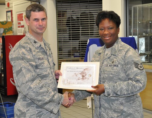U.S. Air Force Col. Michael Plehn, 1st Special Operations Wing commander, hands a certificate of appreciation to U.S. Air Force Staff Sgt. Vielkis McLeod, 1st Special Operations Medical Support Squadron, for her Combined Federal Campaign fundraising efforts during the 2010 Team Hurlburt Mid-Campaign Rally at the mini-mall at Hurlburt Field, Fla., Oct. 19, 2010. The CFC runs through Okaloosa and Walton Counties from Oct. 4 through Nov. 12. (DoD photo by U.S. Air Force Airman 1st Class Joe McFadden/Released)