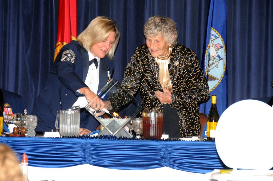 OFFUTT AIR FORCE BASE, Neb. - Chief Master Sergeant Suzan Sangster, 55th Wing command chief and President of the Mess at Offutt's annual Enlisted Dining Out, light sthe centerpiece at the head table with Kathleen McCoy, wife of retired Chief Master Sgt. James McCoy, 6th Chief Master Sergeant of the Air Force, Oct. 15. The primary purpose of a dining-out is to bring military members together in an atmosphere of camaraderie, fellowship and social rapport. The goal is to have a good time and enjoy the company of fellow Airmen. U.S. Air Force photo by Kendra Williams