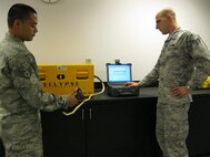 SEYMOUR JOHNSON AIR FORCE BASE, N.C. -- Staff Sgt. Rory Pousson tests a front cockpit stick grip of an F-15E Strike Eagle while SrA Brian Currence operates the Automated Wiring Test System (AWTS). The AWTS equipment can accurately test up to 15,000 wires in less than five minutes, thus largely saving man hours and eliminating repetitive wire testing by hand. Sergeant Poussan and Airman Currence are both 4th Maintenance Group programming technicians. Sergeant Poussan hails from Jacksonville and SrA Currence hails from York, S.C. (U.S. Air Force photo/Robin DeMark)