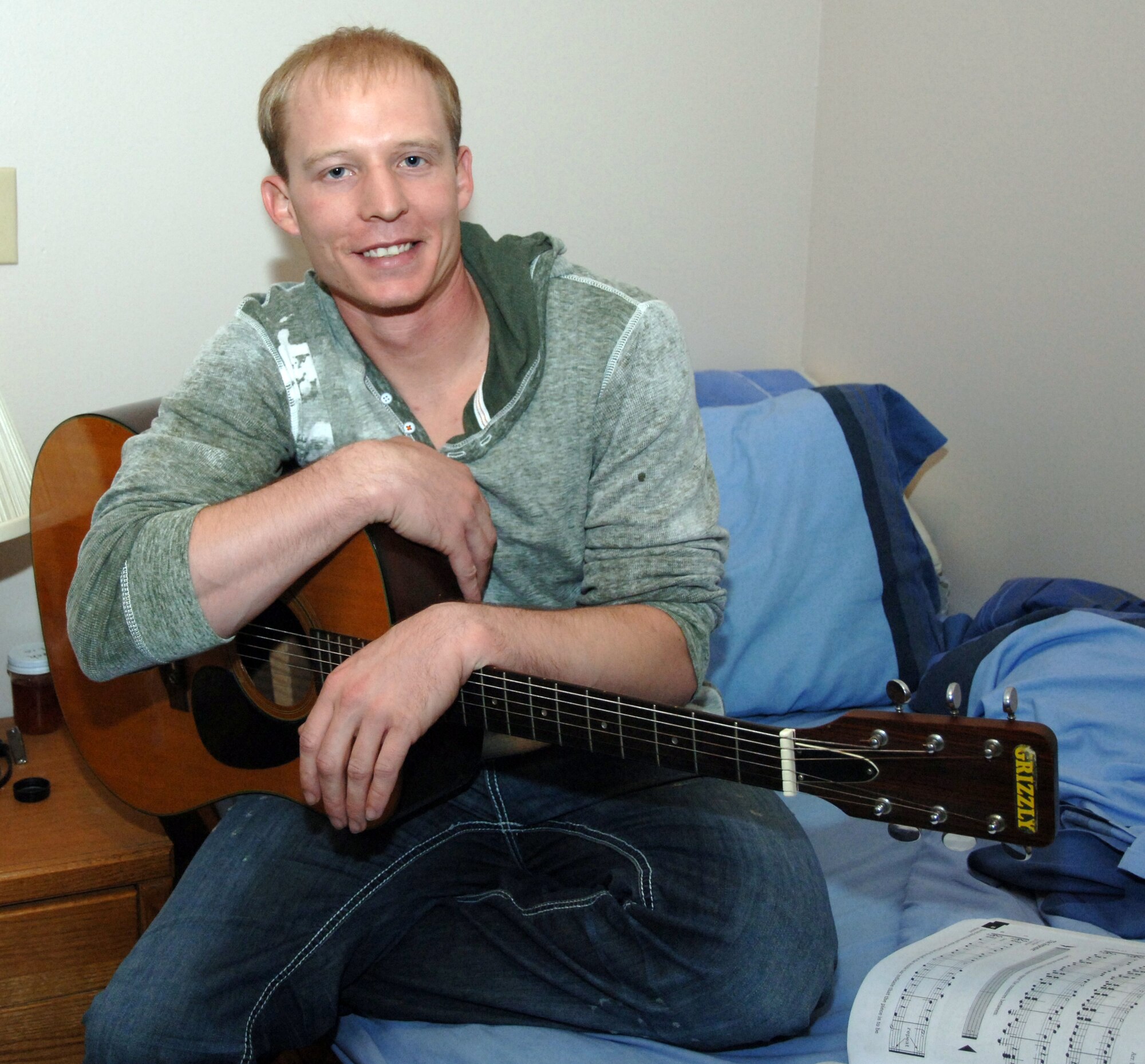 Airman 1st Class Matthew Lang, 319th Security Forces Squadron, takes a break from practicing his guitar to pose for a picture Oct. 18 in his dormitory room on Grand Forks Air Force Base, N.D. Airman Lang is the Warrior of the Week for the week of Oct. 18 to Oct. 22. Warrior of the Week recognizes every day Airmen, who work every day jobs. (U.S. Air Force photo by Airman 1st Class Rachel Waller) 