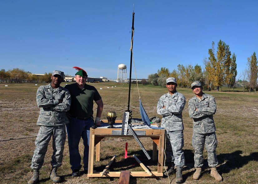 MINOT AIR FORCE BASE, N.D. -- Members of team Eternia pose with their makeshift catapult after receiving the golden pumpkin trophy here Oct. 14. The annual pumpkin throwing contest, hosted by 5th CES, provides Air Force Global Strike Command Airmen at Minot an opportunity to be creative in a competitive setting that instills unit cohesion. (U.S. Air Force photo by Senior Airman Michael J. Veloz)