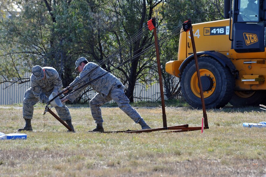 MINOT AIR FORCE BASE, N.D. -- Air Force Global Strike Command Airmen from the 5th Civil Engineer Squadron, prepare their makeshift slingshot for launch here Oct. 14. The annual pumpkin throwing contest, hosted by 5th CES, provides an opportunity for Airmen to be creative in a competitive setting that instills unit cohesion in hopes of receiving the golden pumpkin trophy. (U.S. Air Force photo by Senior Airman Michael J. Veloz)