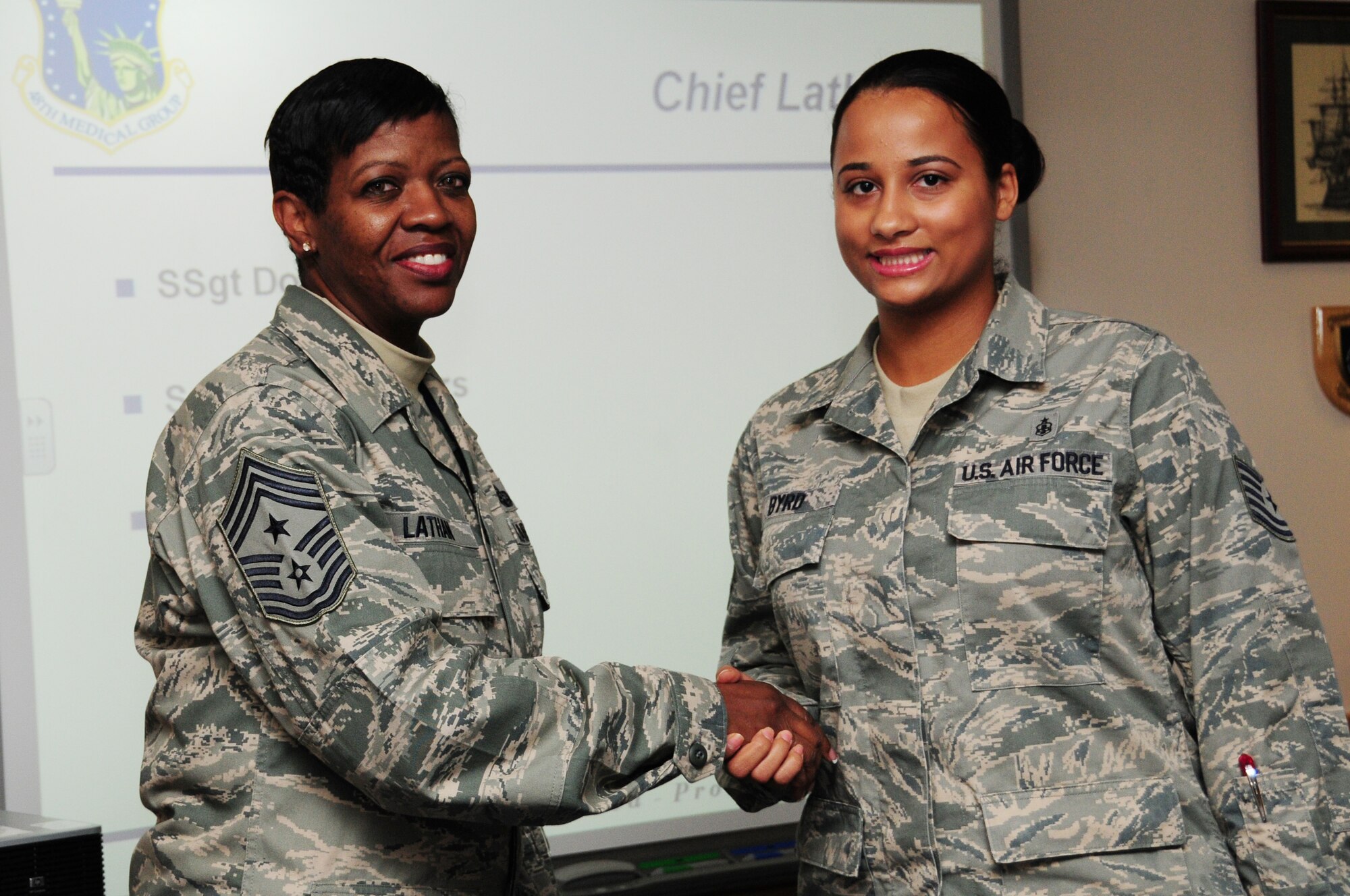 ROYAL AIR FORCE LAKENHEATH, England – Chief Master Sergeant SaRita Lathan, 48th Fighter Wing command chief, presents a coin to Tech Sergeant Tonisha Byrd 48 Medical Support squadron Medical Informations Systems NCO in-charge Oct. 15. Sergeant Byrd was recognized for her outstanding performance and exemplifying Integrity First, Service Before Self and Excellence In All We Do. (U.S. Air Force photo/Airman 1st Class Lausanne Morgan)