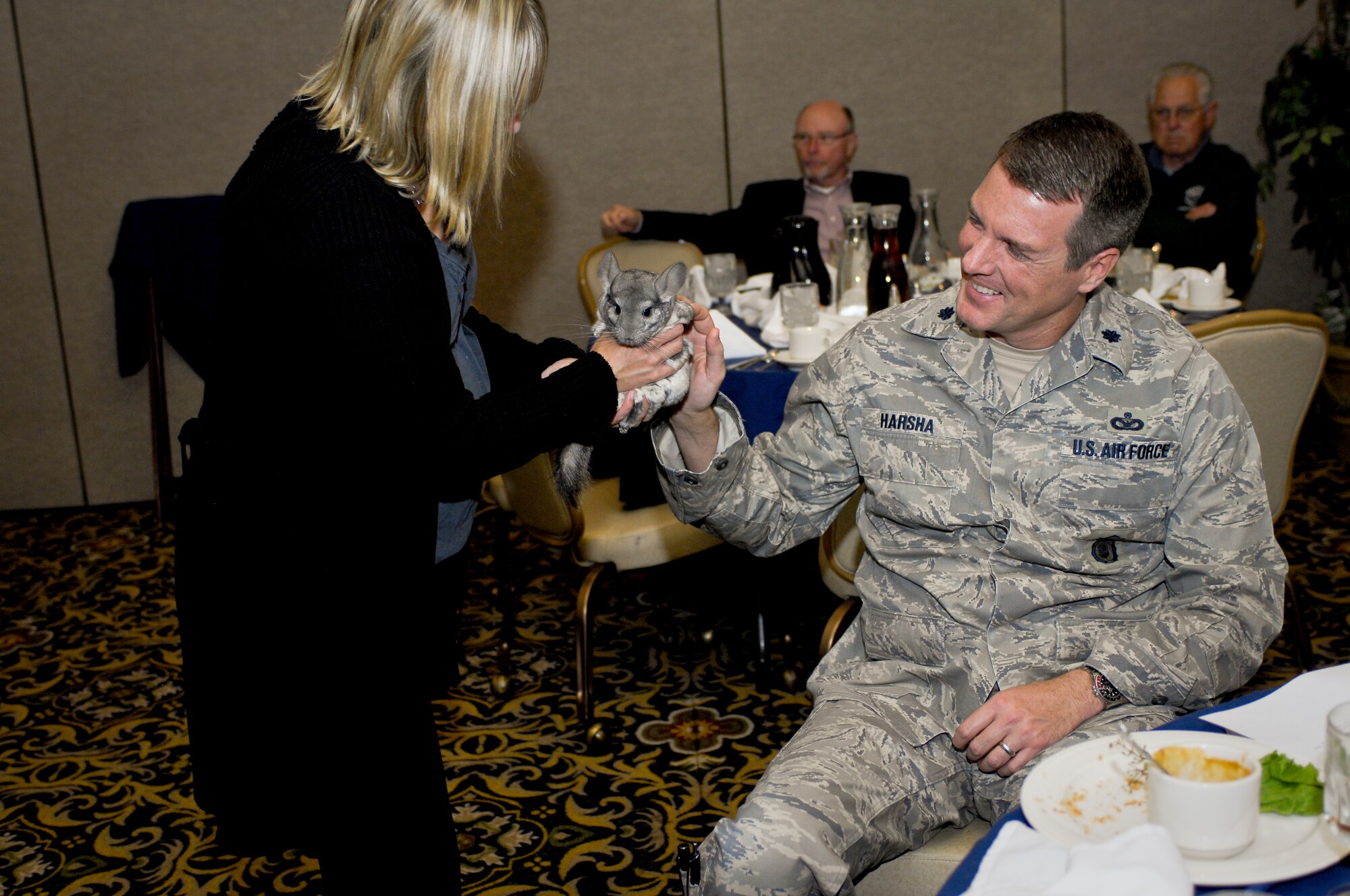 MINOT AIR FORCE BASE, N.D. -- Becky Dewitz, Roosevelt Park Zoo education coordinator, gave Lt. Col. Travis Harsha, 5th Security Forces Squadron command, and members of the Military Affairs Committee an opportunity to pet her chinchilla friend at their monthly luncheon at the Jimmy Doolittle Center here Oct. 14. The MAC holds a monthly luncheon to discuss topics regarding the base and local communities. (U.S. Air Force photo by Senior Airman Benjamin Stratton)