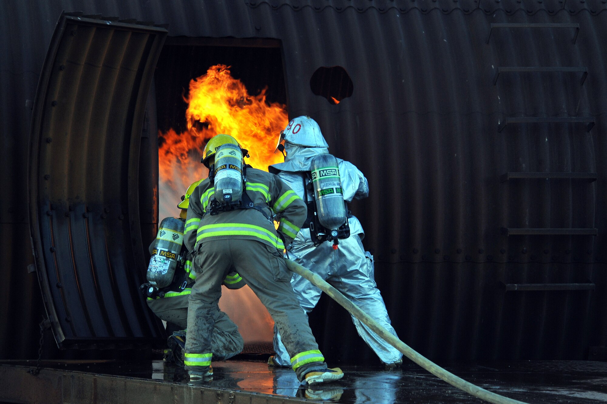 MINOT AIR FORCE BASE, N.D. -- Air Force Global Strike Command Airmen from the 5th Civil Engineer Squadron fire department, team up with the City of Minot fire department during live fire training here Oct. 14. This annual training requirement helps keep both fire departments sharp in their capabilities to save lives in the face of danger. (U.S. Air Force photo by Senior Airman Michael J. Veloz)