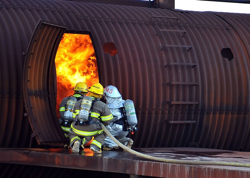 MINOT AIR FORCE BASE, N.D. -- Air Force Global Strike Command Airmen from the 5th Civil Engineer Squadron fire department, team up with the City of Minot fire department during live fire training here Oct. 14. This annual training requirement helps keep both fire departments sharp in their capabilities to save lives in the face of danger. (U.S. Air Force photo by Senior Airman Michael J. Veloz)