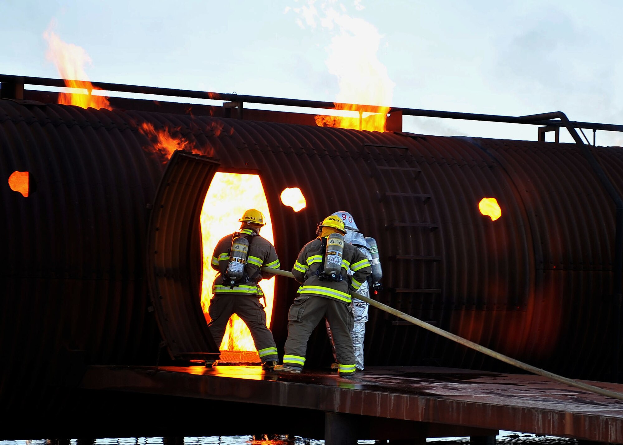 MINOT AIR FORCE BASE, N.D. -- Air Force Global Strike Command Airmen from the 5th Civil Engineer Squadron fire department, team up with the City of Minot fire department during live fire training here Oct. 14. This annual training requirement helps keep both fire departments sharp in their capabilities to save lives in the face of danger. (U.S. Air Force photo by Senior Airman Michael J. Veloz)
