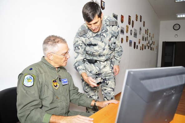 86th Medical Squadron Flight Surgeon Lt. Col. Robert Lehman receives help logging onto a computer from Bulgarian Air Force Maj. Ilai Hristozov prior to a round-table discussion on the history and future of flight medicine, Oct. 19 at Graf Ignatievo Air Base, Bulgaria. Airmen from the 86th Airlift Wing and 435th Air Ground Operations Wing at Ramstein Air Base, Germany, joined Airmen from throughout U.S. Air Forces in Europe in Plovdiv, Bulgaria, for Thracian Fall 2010, an on-site training designed to build the partnership between the U.S. and Bulgarian Air Force. (U.S. Air Force photo by Tech. Sgt. Michael Voss) 
