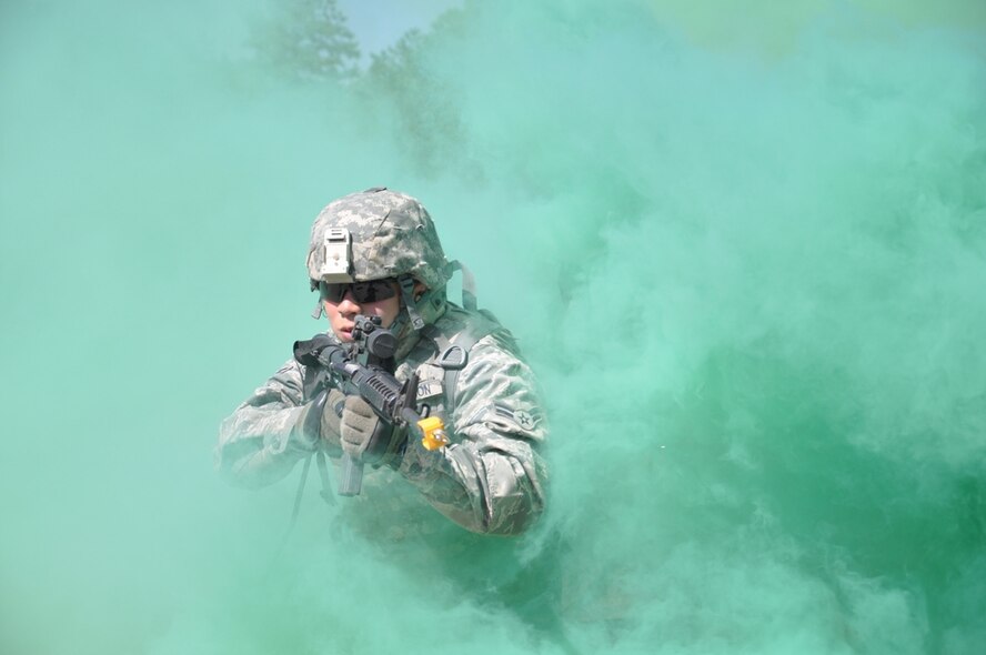 Airman 1st Class John Fallesgon, 633rd Force Support Squadron food services chef at Langley Air Force Base, Va., peers through the smoke to engage enemy during a foot patrol at Combat Skills Training here Sept. 2. The 602nd Training Group (P) Detachment 6 produces approximately 2,400 joint expeditionary tasking Airmen each year. (U.S. Air Force photo/Chief Master Sgt. David Richards)