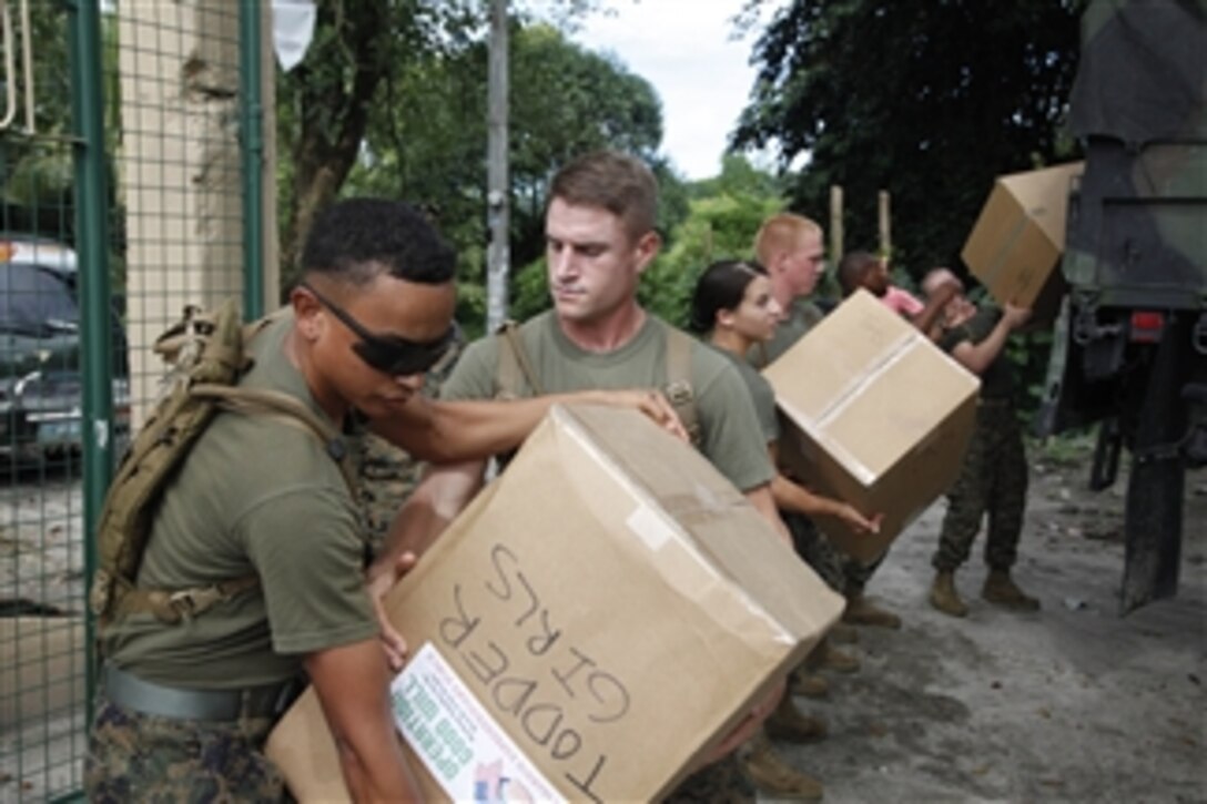 U.S. Marines and sailors with Marine Air Group 36, 3rd Marine Expeditionary Brigade unload supplies at Calumpang Elementary School in Mabalacat, Pampanga, Philippines, as part of Operation Goodwill during Amphibious Landing Exercise FY 2011 on Oct. 14, 2010.  The Marines and sailors provided sports equipment, school supplies, shoes and desks as part of Operation Goodwill.  