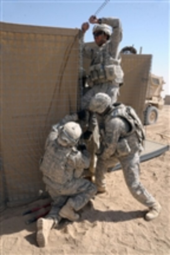 U.S. Army soldiers with the 864th Engineer Battalion, assigned to Combat Outpost Terminator, continue a second day setting up HESCO barriers to establish the perimeter of a strong-point operating position in the Zhari district of Kandahar province, Afghanistan, on Sept. 16, 2010.  The combat engineers were given 48 hours to establish a defensive perimeter and six days to fully complete the construction of the new combat outpost.  