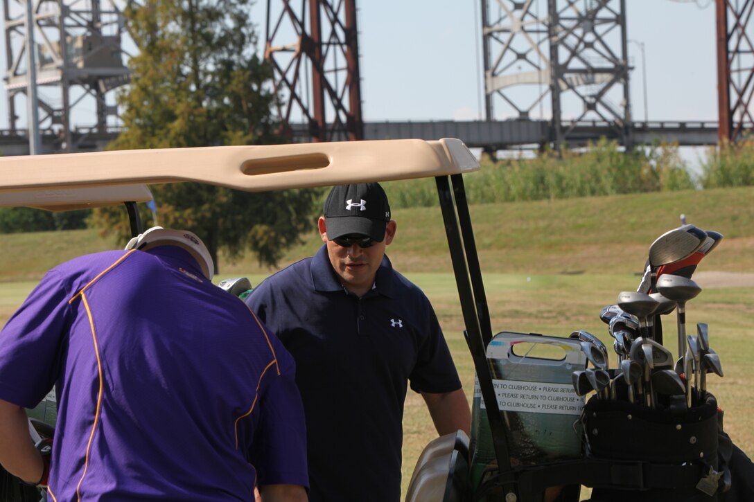 Gunnery Sgt. Steven Saucedo, Installation Personnel Administration Center active maintenance chief, looks in his golf cart for equipment in order to start playing golf in a tournament at Bayou Berriere Golf Club, Belle Chasse, La., OCt. 19, 2010. The golf tournament was a fundraiser for the Marine Corps Ball.