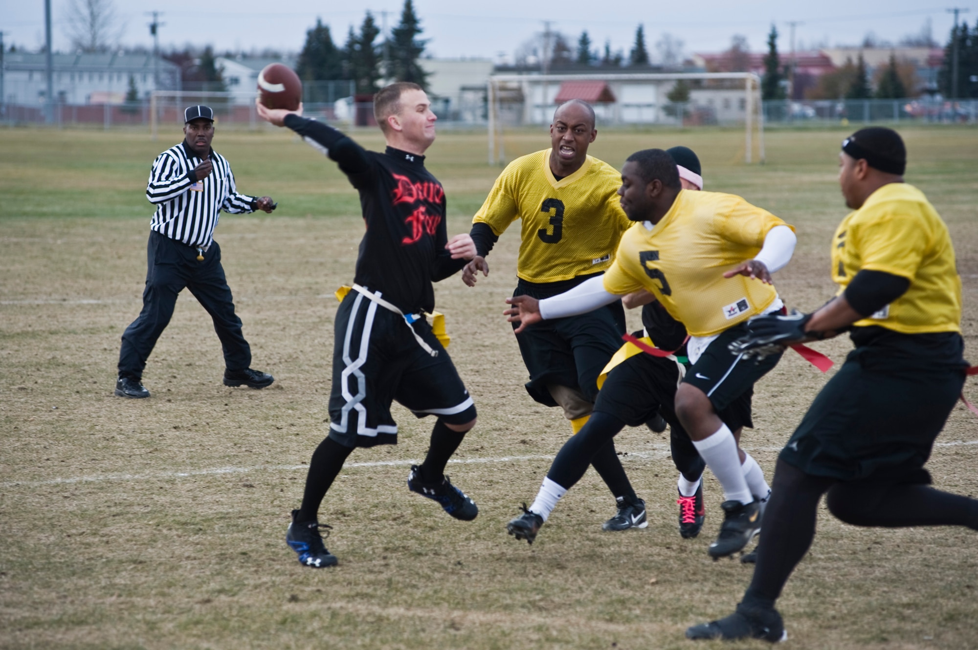 Fort Wainwright quarterback Joseph Mctyre throws the ball while running out of the pocket trying to avoid a sack. (U.S. Air Force photo/A1C Christopher Gross)