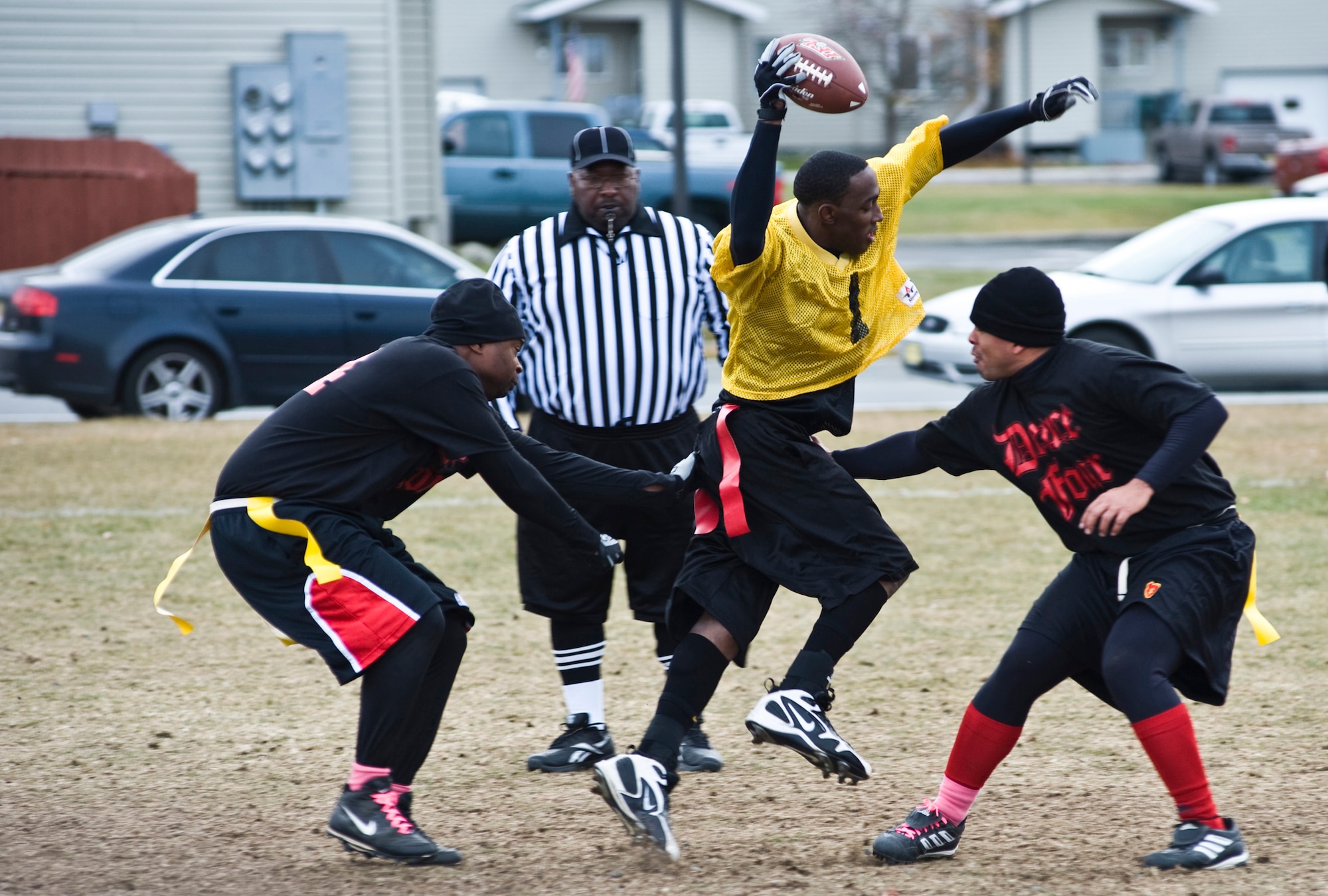 Joint Base Elmendorf-Richardson quarterback Patrick Spence tries to squeeze himself by some Fort Wainwright defenders during a football game, Saturday. JBER beat Fort Wainwright 14-13 to declare themselves the top football team in the Last Frontier. Representing JBER was the 3rd Battalion, 509th Infantry Regiment (Airborne), and representing Fort Wainwright was 1st Battalion, 24th Infantry Regiment. (U.S. Air Force photo/A1C Christopher Gross)