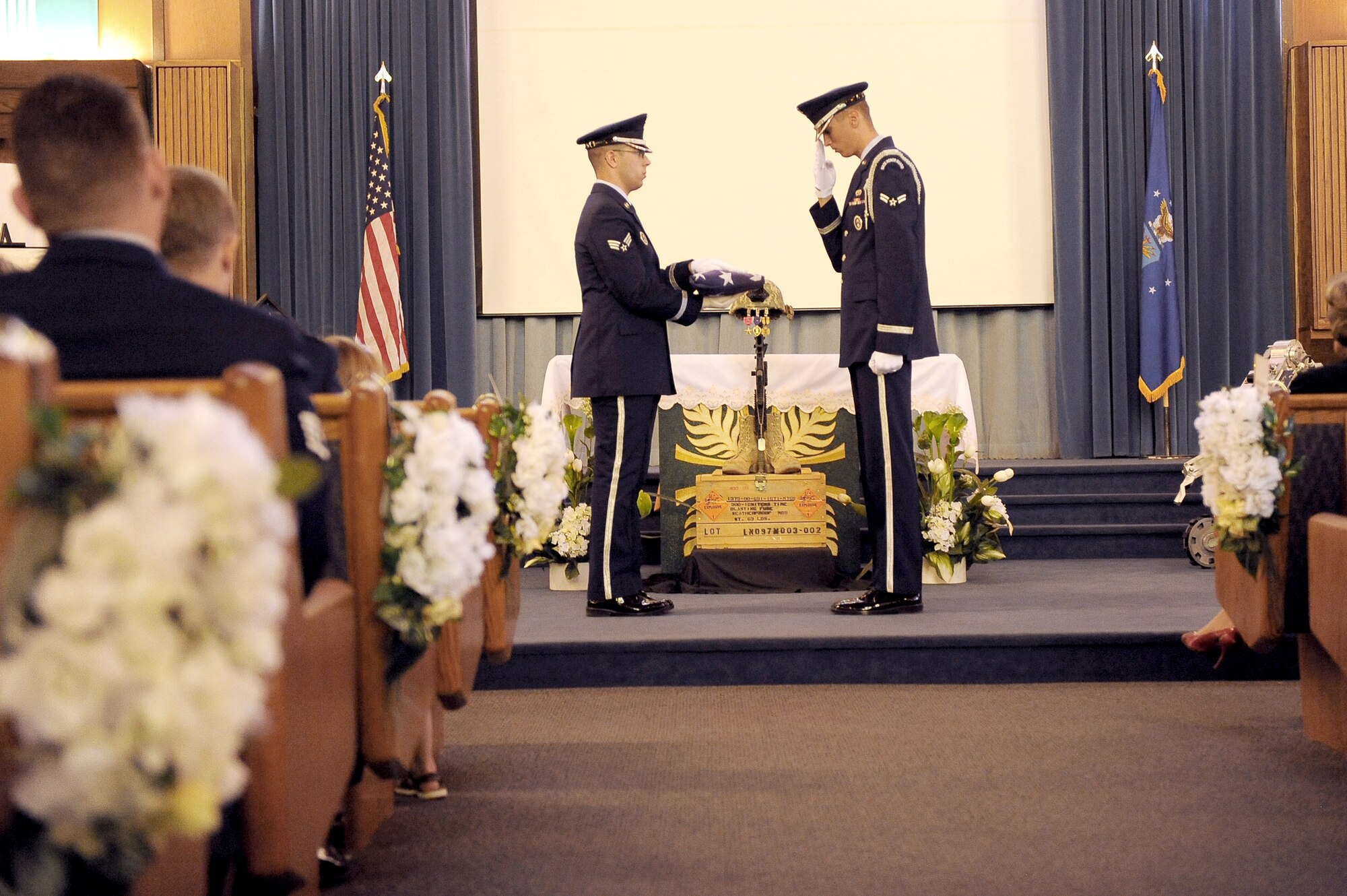 Nellis Air Force Base Honor Guard members perform the flag-folding ceremony inside the base chapel during a memorial service for Senior Airman Michael Buras Oct. 15, 2010, at Nellis AFB, Nev. Airman Buras was an explosive ordnance disposal journeyman assigned to the 99th Civil Engineer Squadron when he was killed in action while responding to a roadside bomb Sept. 21, 2010, in Afghanistan. (U.S. Air Force photo/Senior Airman Stephanie Rubi)