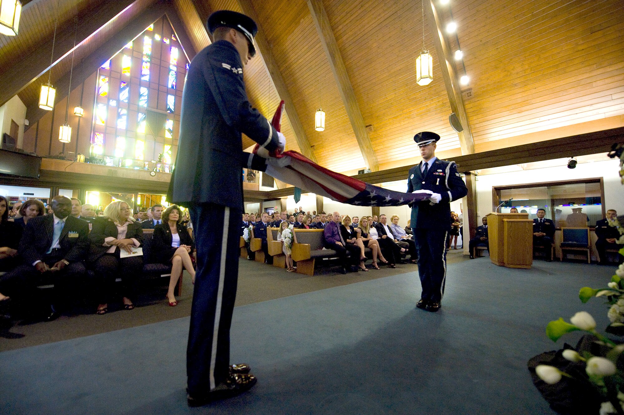 Nellis Air Force Base Honor Guard members perform the flag-folding ceremony inside the base chapel during a memorial service for Senior Airman Michael Buras Oct. 15, 2010, at Nellis AFB, Nev. Airman Buras was an explosive ordnance disposal journeyman assigned to the 99th Civil Engineer Squadron when he was killed in action while responding to a roadside bomb Sept. 21, 2010, in Afghanistan. (U.S. Air Force photo/Senior Airman Brett Clashman)