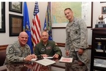 MINOT AIR FORCE BASE, N.D. -- Chief Master Sgt. John L. Hoffman, 91st Missile Wing command chief, Col. Fred Stoss, 91st MW commander, and Capt. Lucas Eby, 91st Security Support Squadron combined federal campaign officer, all pose for a photo after signing their CFC form here Oct. 14. The CFC is made up of local campaigns that organize the annual fund raising in federal workplaces in the United States and abroad. (U.S. Air Force photo by Airman 1st Class Aaron-Forrest Wainwright)