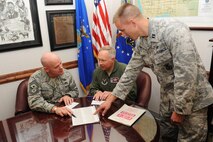 MINOT AIR FORCE BASE, N.D. -- Capt. Lucas Eby, 91st Security Support Squadron combined federal campaign officer, shows Chief Master Sgt. John L. Hoffman, 91st Missile Wing command chief, and Col. Fred Stoss, 91st MW commander, some of the charities available that they can donate to during this year’s CFC drive here Oct. 14. The CFC is made up of local campaigns that organize the annual fund raising in federal workplaces in the United States and abroad. (U.S. Air Force photo by Airman 1st Class Aaron-Forrest Wainwright)
