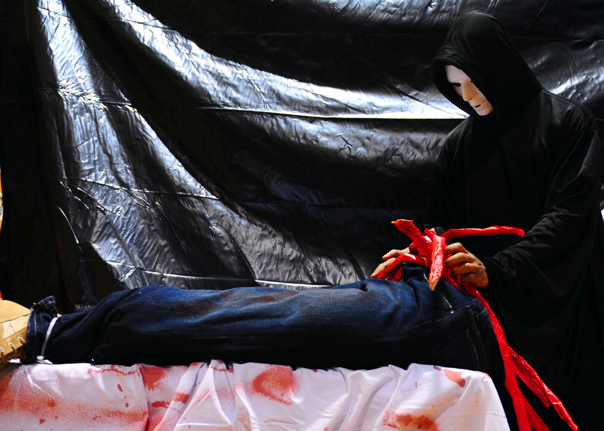 DYESS AIR FORCE BASE, Texas—Airman 1st Class Najee Holland, 7th Munitions Squadron, stuffs imitation intestines into a dummy for a haunted house Oct. 20 at the Dyess Youth Center here. Airmen from 7th Munitions Squadron hold a haunted house each year. This year it will be held Oct. 22-23rd from 6 to 11 p.m. at the Youth Center. (U.S. Air Force photo/ Airman 1st Class Brittney Smolinski)