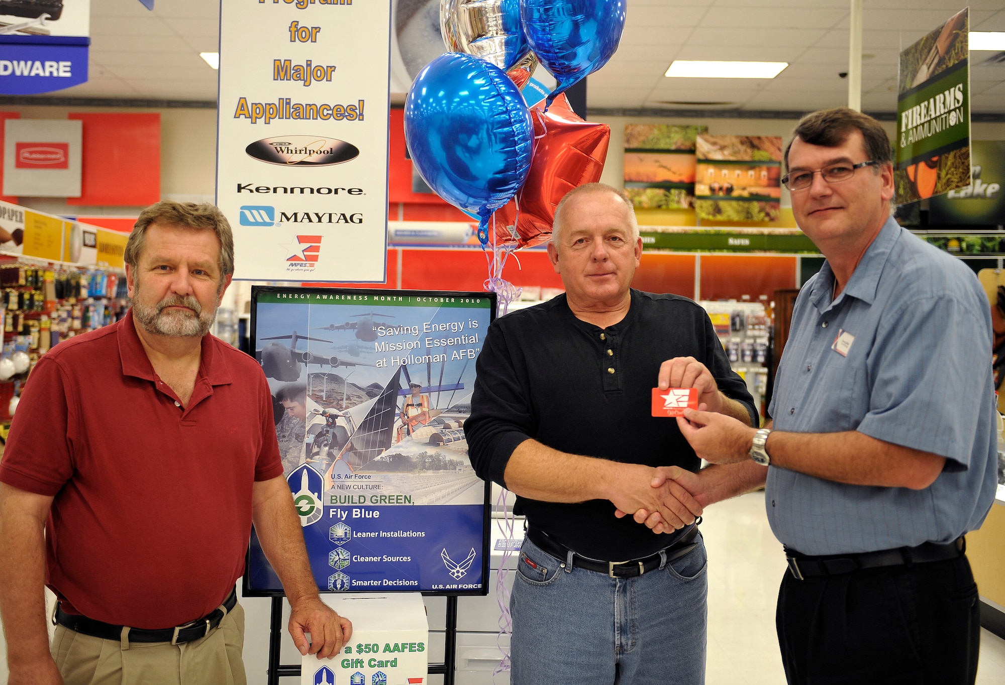 HOLLOMAN AIR FORCE BASE, N.M. -- Gary Krivokapich, 49th Civil Engineer Squadron Resource Efficiency manager, and Georg Main, Base Exchange general manager, present John Tanis, 846th Test Squadron Center, with a $50 gift certificate for his winning October Energy Awareness slogan "Save that power for another hour -- Holloman AFB" Oct. 18, 2010. The Army and Air Force Exchange Service and the 49th CES hosted a base-wide energy awareness slogan contest to promote energy saving and conservation at Holloman. Since 1991, the Department of Energy has used this month to kick off its annual energy awareness campaign, promoting efficient uses of energy. (U.S. Air Force photo by Senior Airman Veronica Stamps/Released)