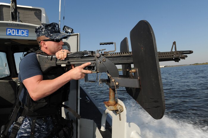 Master at Arms 1st Class Jacob Moore mans an M-60 machine gun while patrolling the waters of the Cooper River Oct. 19, 2010, on Joint Base Charleston-Weapons Station, S.C. With the merging of Weapons Station and Air Base, the Security Department previously under Naval Weapons Station Charleston now operates under the 628th Security Forces Squadron.   The members of the 628 SFS on the Weapons Station patrol the waters of the Cooper River 24/7 to provide protection for facilities along the shoreline. (U.S. Air Force photo/James M. Bowman)