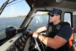 Master-at-Arms 2nd Class Nicholas Green steers a security boat while patrolling the waters of the Cooper River Oct. 19, 2010, on Joint Base Charleston-Weapons Station, S.C. MA2 Green and his team on the Weapons Station also provides land-based security for the entire Weapons Station. MA2 Green is a security forces member with the 628th Security Forces Squadron. ( U.S. Air Force photo/James M. Bowman)