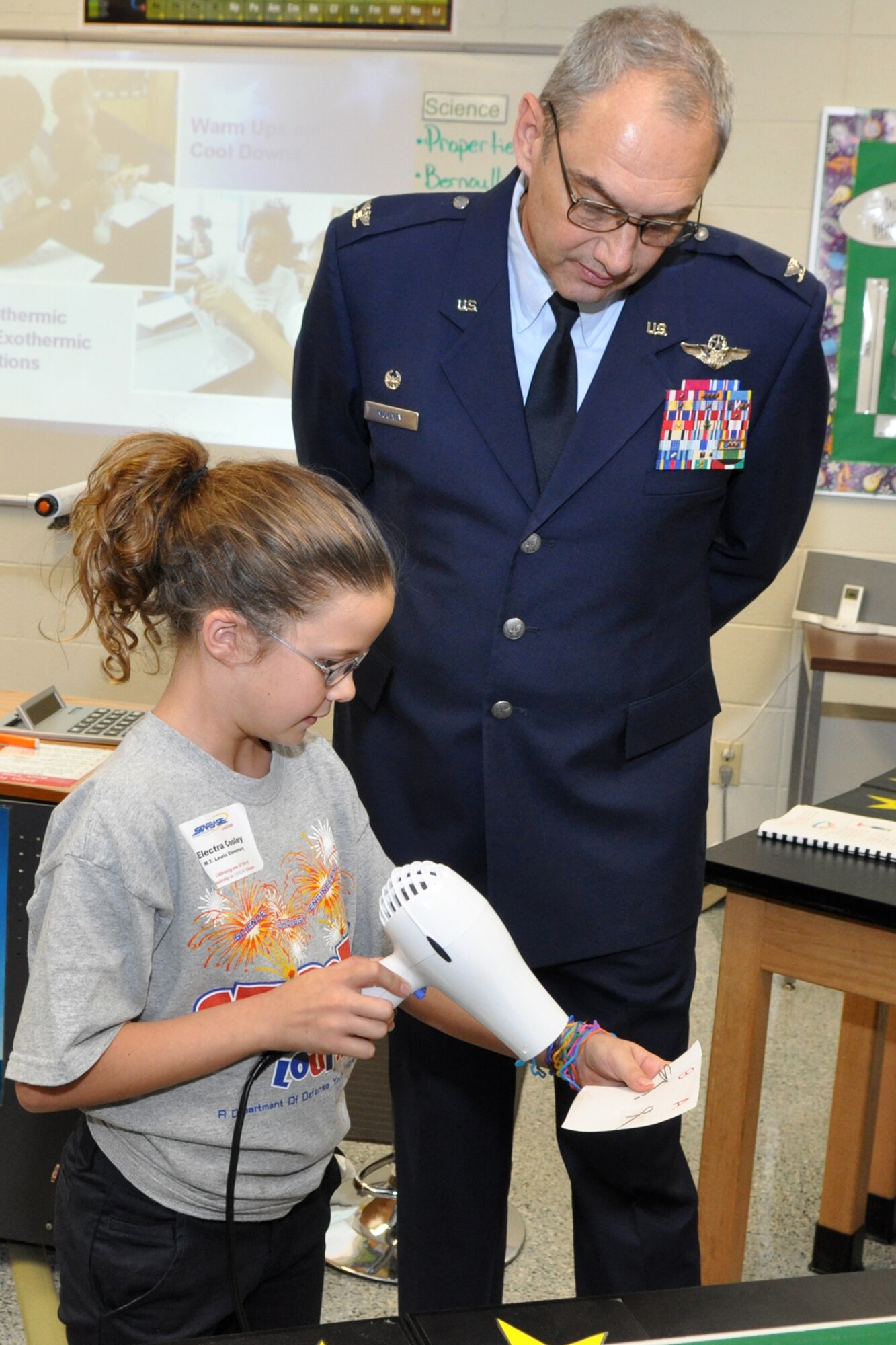 Col. John J. Mooney III, commander of the 917th Wing, receives a lesson in Nanotechnology from Electra Cooley during the grand re-opening celebration at the newly remodeled STARBASE facility on Barksdale Air Force Base, La., Oct. 18, 2010. Electra, who is a fifth-grade student at W.T. Lewis Elementary School, was demonstrating how materials react to cold and heat. STARBASE students have a unique opportunity to explore the physical properties of several nanoengineered materials and determine their usefulness in meeting a clearly defined human need. (U.S. Air Force photo/Tech. Sgt. Jeff Walston)