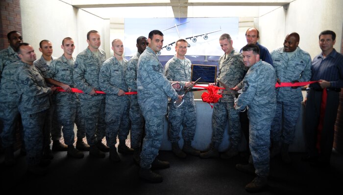 Airmen and civilians gather for a picture during the ribbon cutting ceremony for the completion of the Air Base headquarters foyer renovation project Oct. 18, 2010, on Joint Base Charleston-Air Base, S.C. Fifteen volunteers spent hundreds of man hours constructing a replica of the Arthur Ravenel Jr. Bridge to lay over a 12-foot by eight-foot photo that had been mounted on the wall. To finish the project, 1st Lt. Kipp Williams ordered a scale model of a C-17 Globemaster III to be hung in front of the bridge making it a three-dimensional display. The project took more than nine months to complete from start to finish. The volunteers in the photo from left to right are Airman 1st Class Ronald Williams, Staff Sgt. Nathan Hargett, Senior Airman Julio Rodriguez, Airman 1st Class James Moreland, Tech. Sgt. Raemon Kimbrell, Airman 1st Class Justin Marcum, Senior Airman Shawn Milligan, Tech. Sgt.Tim Thornton, Tech. Sgt. Randall Pearce, Tech. Sgt. Nick Rykal, Senior Master Sgt. Guy Toney, Randall Gillum, Master Sgt. Larry Madison and James  Bowman. (U.S. Air Force photo/Senior Airman Timothy Taylor)