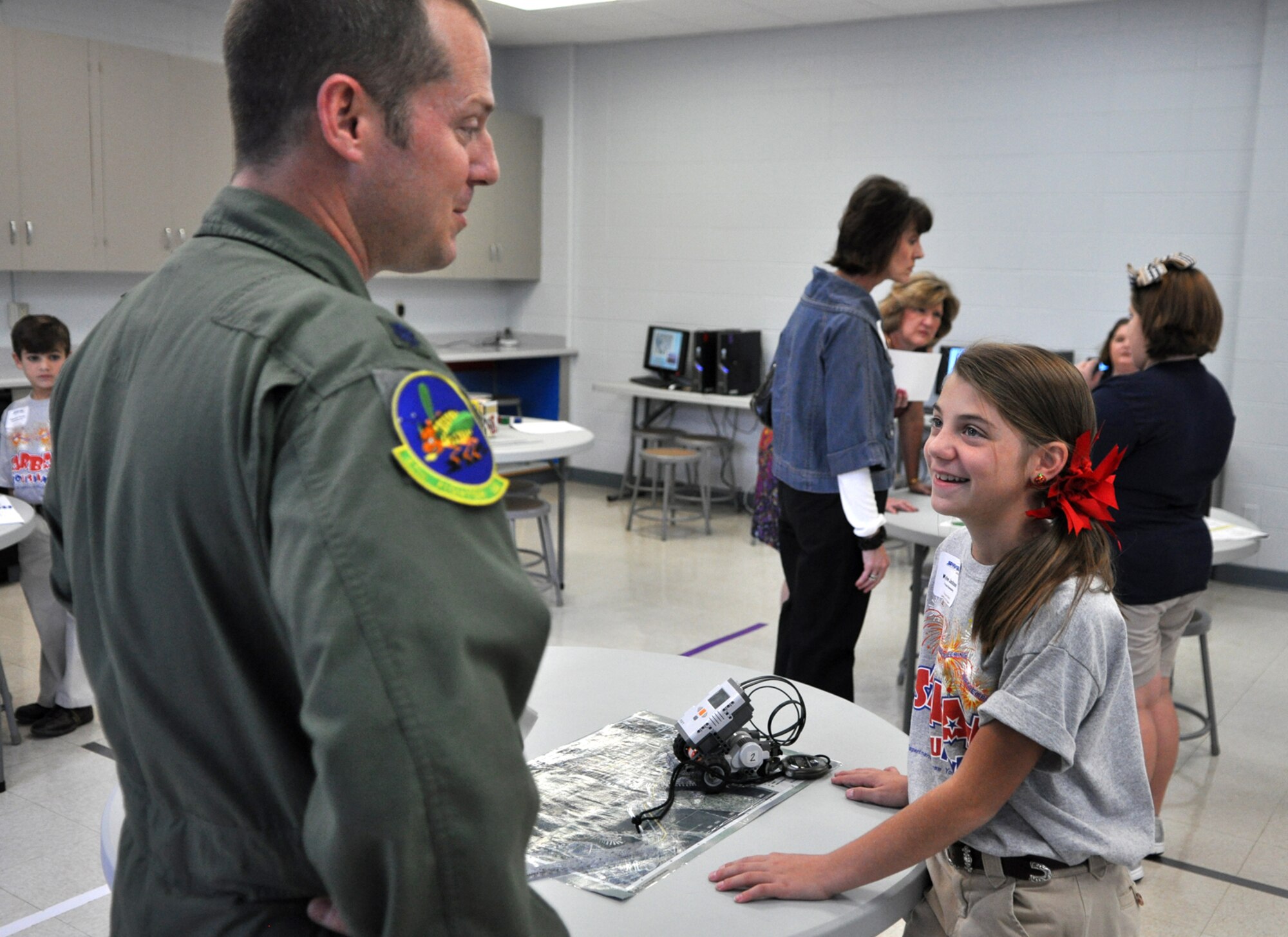 Kylee Jackson, a fifth-grade student at Princeton Elementary in Haughton, La., discusses robotic programming with Lt. Col. James Travis, commander of the 47th Fighter Squadron, during the grand re-opening celebration at the newly remodeled STARBASE facility on Barksdale Air Force Base, La., Oct. 18, 2010. Kylee is the daughter of Senior Airman Rikki Welch, who is a member of the 917th Wing at Barksdale. The 917th Wing at Barksdale AFB, which is a sponsor of the STARBASE program, supplied the lab with 32 refurbished computers for the students use. (U.S. Air Force photo/Tech. Sgt. Jeff Walston)