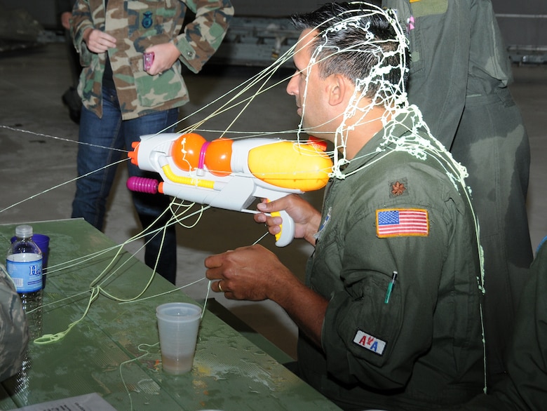 Maj. Michael "Two Dog" Galvin is unsuccessful in his attempt to defend himself against a silly string attack during the first 107th Combat dining-in held Oct. 16. (U.S. Air Force Photo/Staff Sgt. Peter Dean)