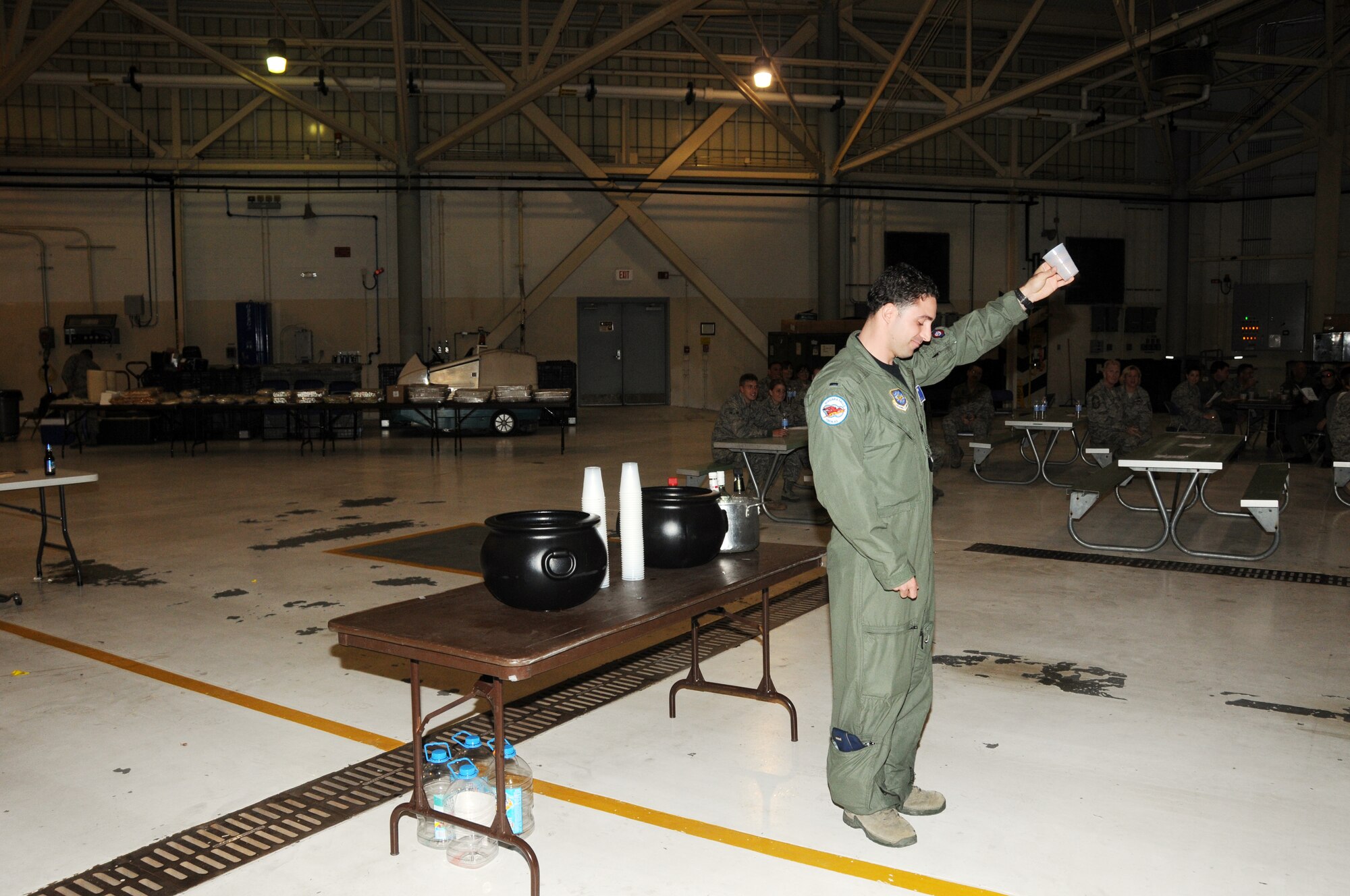 Capt. Joseph Neglia, Officer of the Mess demonstrated the Grog Bowl procedure that violators of one of the 21 rules must visit. The first rule was "Thy president is always right" (Col. Patrick Ginavan) and the last was "any questions please refer back to rule number one." (U.S. Air Force Photo/Staff Sgt. Peter Dean)