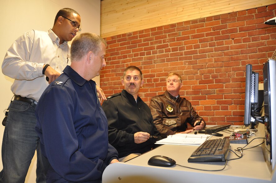 Jonathan Jones give flight instruction to Col. Brett Newman, Capt. Kevin Hempel and Col. Ron Wilt at the Base Camp Space Shuttle simulator.(Air Force Photo/Paul Zadach)