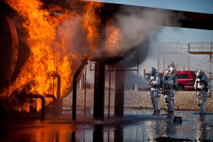 NELLIS AIR FORCE BASE, Nev. -- Staff Sgt. Aric Andrade, 99th Civil Engineer Squadron fire department crew chief, instructs Brig. Gen. David Thompson, U.S Air Force Warfare Center vice commander, on the proper technique to attack a structural fire at the Nellis live-fire training facility Oct. 18. The 99th Civil Engineer Squadron and fire emergency services flight invited Nellis senior leaders to a live-fire aircraft and structural exercise so they could experience some of the challenges firefighters encounter during real-world situations. (U.S. Air Force photo by Tech. Sgt. Michael R. Holzworth)(Released)