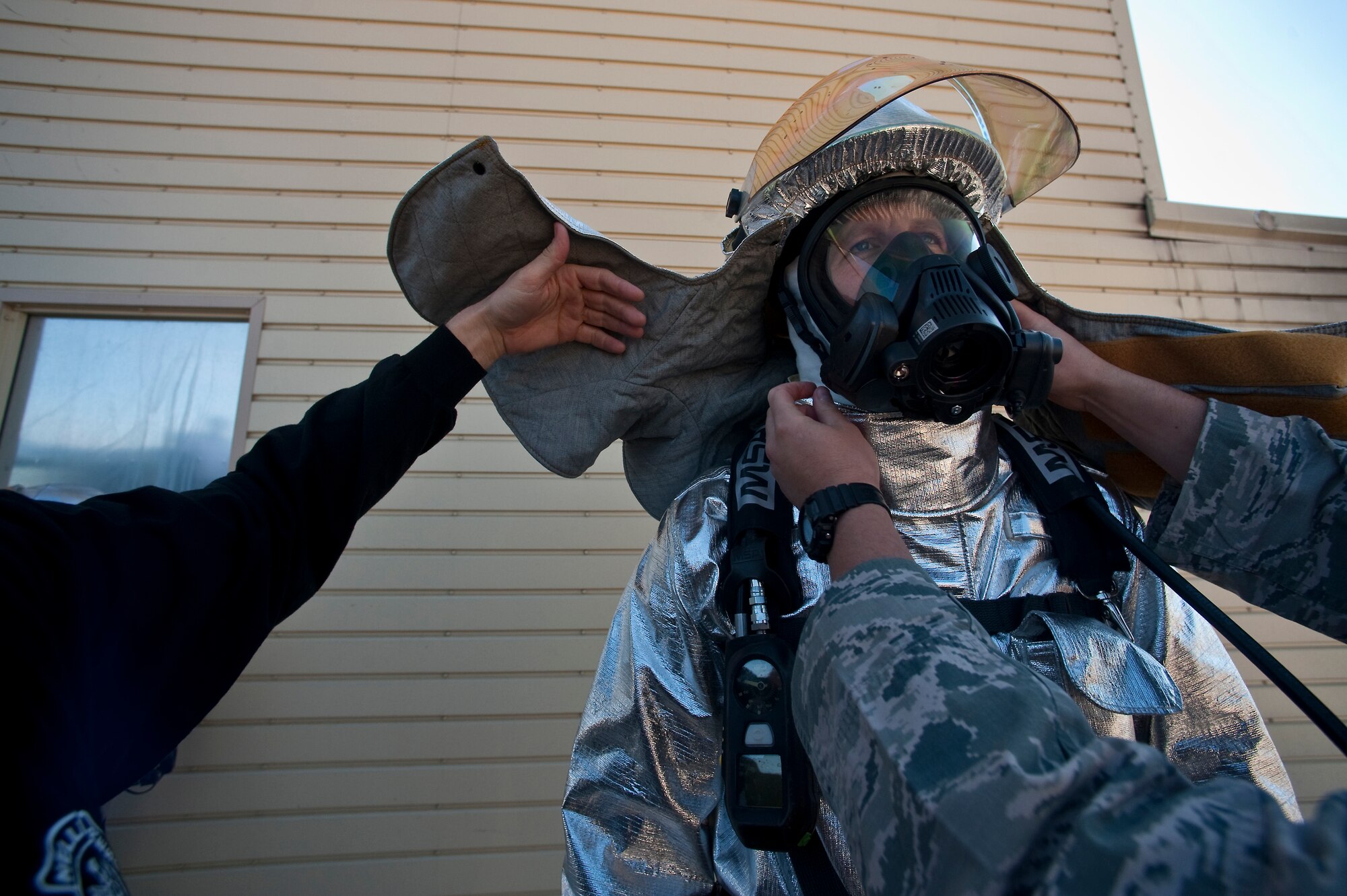 NELLIS AIR FORCE BASE, Nev. --Staff Sgt. Christopher Pennock a airborne firefighter with the 99th Civil Engineer Squadron Fire Department conducts a buddy check with Brig. Gen. David Thompson, U.S Air Force Warfare Center vice commander before fighting a simulated structural fire at the Nellis live fire training facility Oct. 18. The 99th Civil Engineer Squadron and Fire Emergency Services Flight invited the Wing leadership to a live-fire aircraft and structural exercise so they could get to experience some of the challenges firefighters encounter during real world situations. (U.S. Air Force photo / Tech. Sgt. Michael R. Holzworth)(Released)

