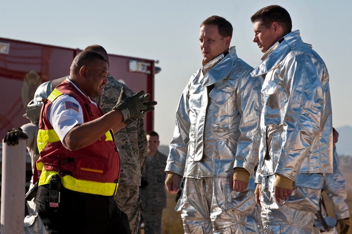 NELLIS AIR FORCE BASE, Nev. -- Mr. Gordon Mincey, 99th Civil Engineer Squadron Fire Department assistant chief of training, gives a safety briefing to Col. Steven Garland, 99th Air Base Wing commander, and Brig. Gen. David Thompson, U.S Air Force Warfare Center vice commander, before fighting a simulated aircraft fire at the Nellis live fire training facility Oct. 18. The 99th Civil Engineer Squadron and fire emergency services flight invited Nellis senior leaders to a live-fire aircraft and structural exercise so they could experience some of the challenges firefighters encounter during real-world situations. (U.S. Air Force photo by Tech. Sgt. Michael R. Holzworth)(Released)