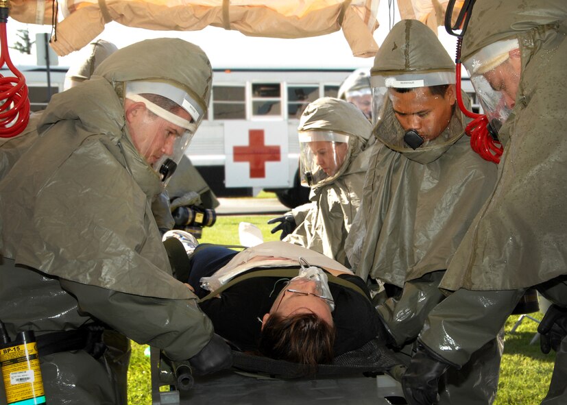 Left to right, Airman 1st Class Anthony Molosz member of the 60th Dental Squadron, Senior Airman Holly Fuentes member of the  60th Medical Support Squadron, Airman 1st Class Raneil Buenviaje member of the 60th Surgical Operations Squadron and Staff Sergeant Chris Varoz member of the 60th Dental Squadron  decontaminate a simulated casualty during the Travis Response Exercise prior to entering David Grant Medical Center for further medical treatment. (U.S. Air Force photo by Civ/Nan Wylie)   
