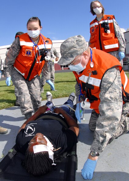 Left to right, Airman 1st Class Michelle Doyle,  Colonel Thomas Beach and Airman 1st Class Brianna Panko examine a simulated casualty  during the Travis Response Exercise on September 23rd.  All are members of the 60th Medical Operations Squadron.  (U.S. Air Force photo by Civ/Nan Wylie)