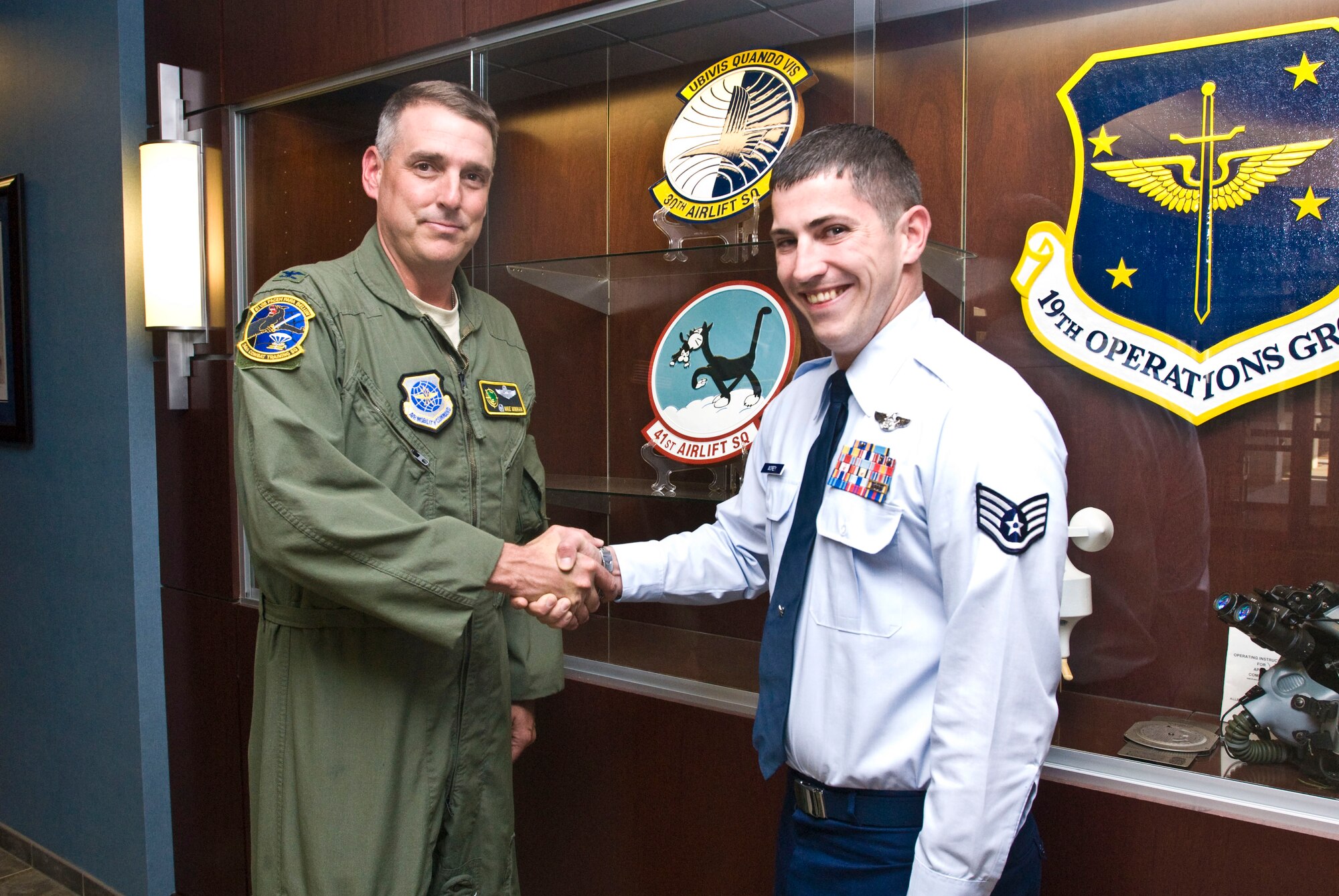 Col. Mike Minihan (left), 19th Airlift Wing commander, presents a coin Oct, 18 to Staff Sgt. Jesse Morey, 19th Operations Group NCO-in-charge of publications, for his selection as the Combat Airlifter of the Week. Sergeant Morey releases operations technical order changes to 19th OG aircrews and is leading a first-of-its-kind $500,000 e-reader program in Air Mobility Command. (U.S. Air Force photo by Staff Sgt. Nestor Cruz)