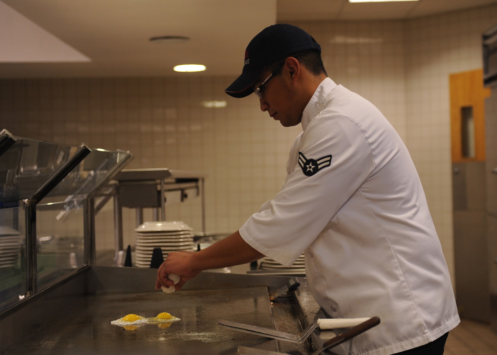 DYESS AIR FORCE BASE, Texas --Airman 1st Class Michael Hernandez, 7th Force Support Squadron services specialist, fries eggs for an Airman at the Longhorn Dining Facility here Oct. 20. The mission of the 7 FSS is to develop, sustain and regenerate people through first-class customer service, the first time and every time. For the dining facility hours of operation, logon to http://www.dyessfss.com/Food_Service.html or call (325) 696-2421. (U.S. Air Force photo/ Senior Airman Felicia Juenke)