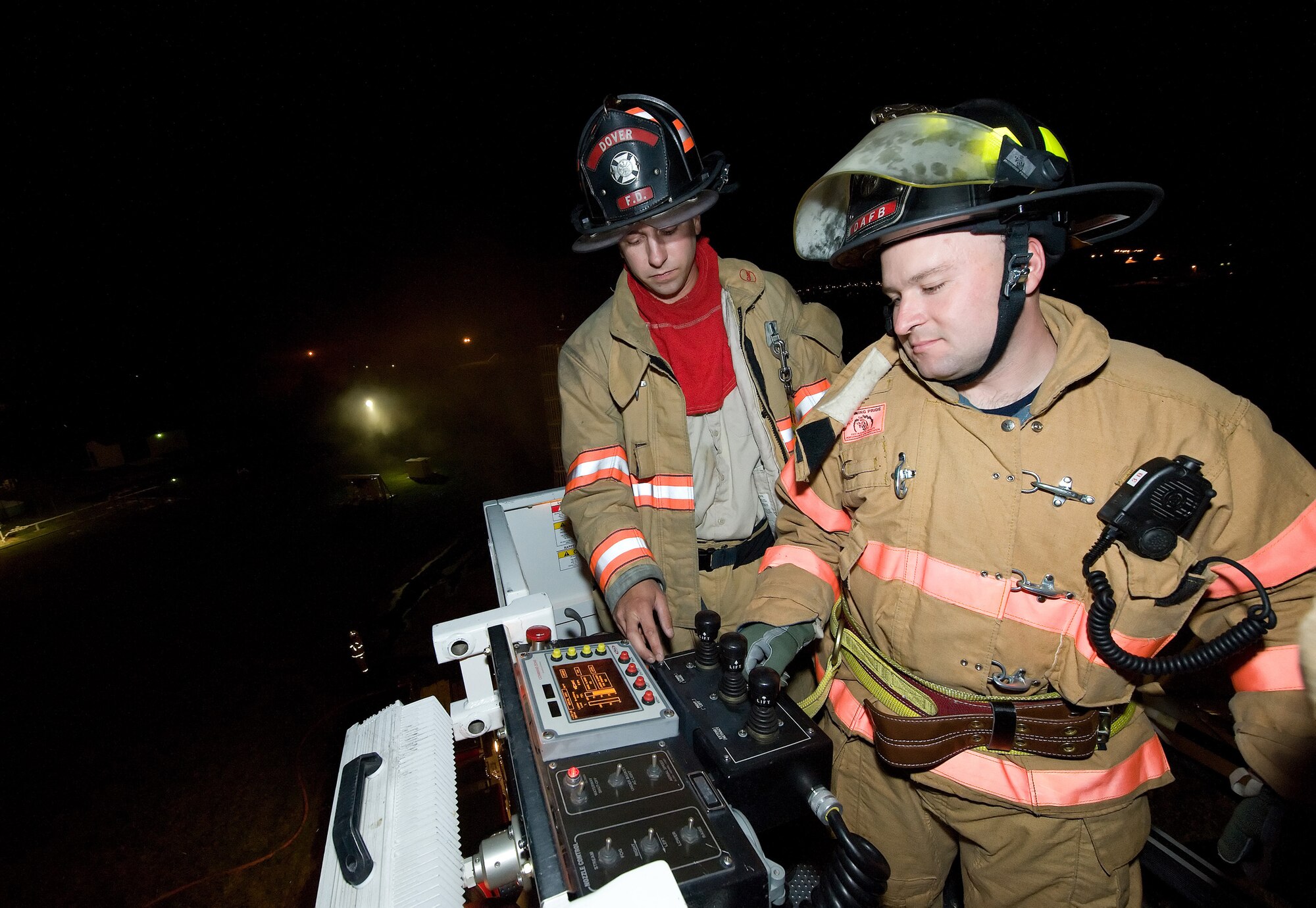 (Left) Tim Brown, City of Dover firefighter, showcases the ladder truck
to James Herr, 512th Civil Engineer Squadron firefighter, during a live fire
exercise Oct. 19, 2010, at the fire training area on Dover Air Force Base,
Del. This exercise brought together the two mutual aid partners so they
could train together during one of several semi-annual exercises this year.
(U.S. Air Force photo by Jason Minto/Released)
