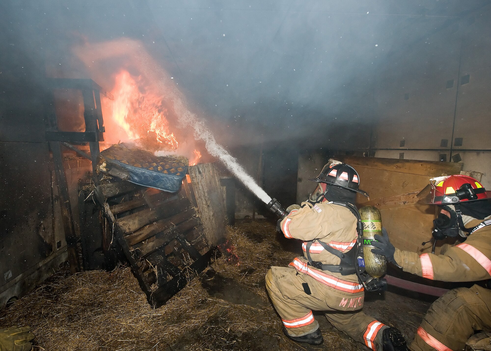 (Left) Tim Brown, City of Dover firefighter, and Staff Sgt. John
Bodnar, 436th Civil Engineer Squadron firefighter, work to put out a blaze
in a simulated building fire during a live fire exercise Oct. 19, 2010, at
the fire training area on Dover Air Force Base, Del. The exercise is one of
several semi-annual exercises this year, which often have Dover AFB
firefighters working in tandem with City of Dover firefighters. (U.S. Air
Force photo by Jason Minto/Released)
