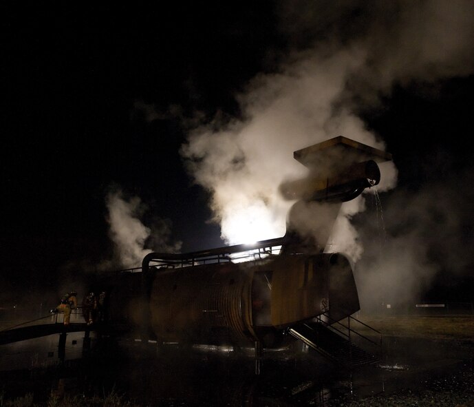 Dover Air Force Base and City of Dover firefighters inspect the resultsof a simulated aircraft fire during a live fire exercise Oct. 19, 2010, atthe fire training area on Dover AFB, Del. this exercise was one of severalsemi-annual exercises that Dover AFB has done this year with assistance ofthe City of Dover. (U.S. Air Force photo by Jason Minto/Released)