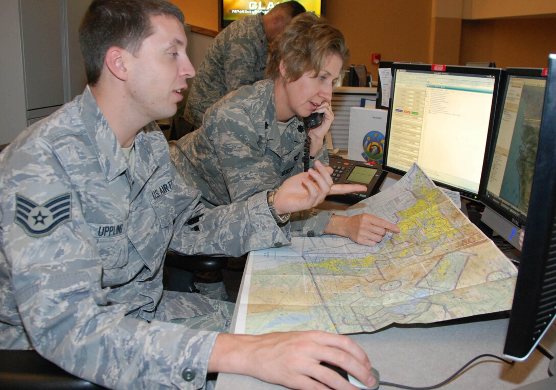 Staff Sgt. Christopher Uppling (left) and Lt. Col. Julie Eubanks, both controllers with the Air Force Rescue Coordination Center at Tyndall AFB, Fla., establish communications with their counterparts at Mexico’s Rescue Coordination Center during a search for a missing airplane near the U.S.-Mexico border Oct. 15, 2010.  The controllers assisted in the coordination of locating the fatal crash site.  (U.S. Air Force photo by Capt. Jared Scott)