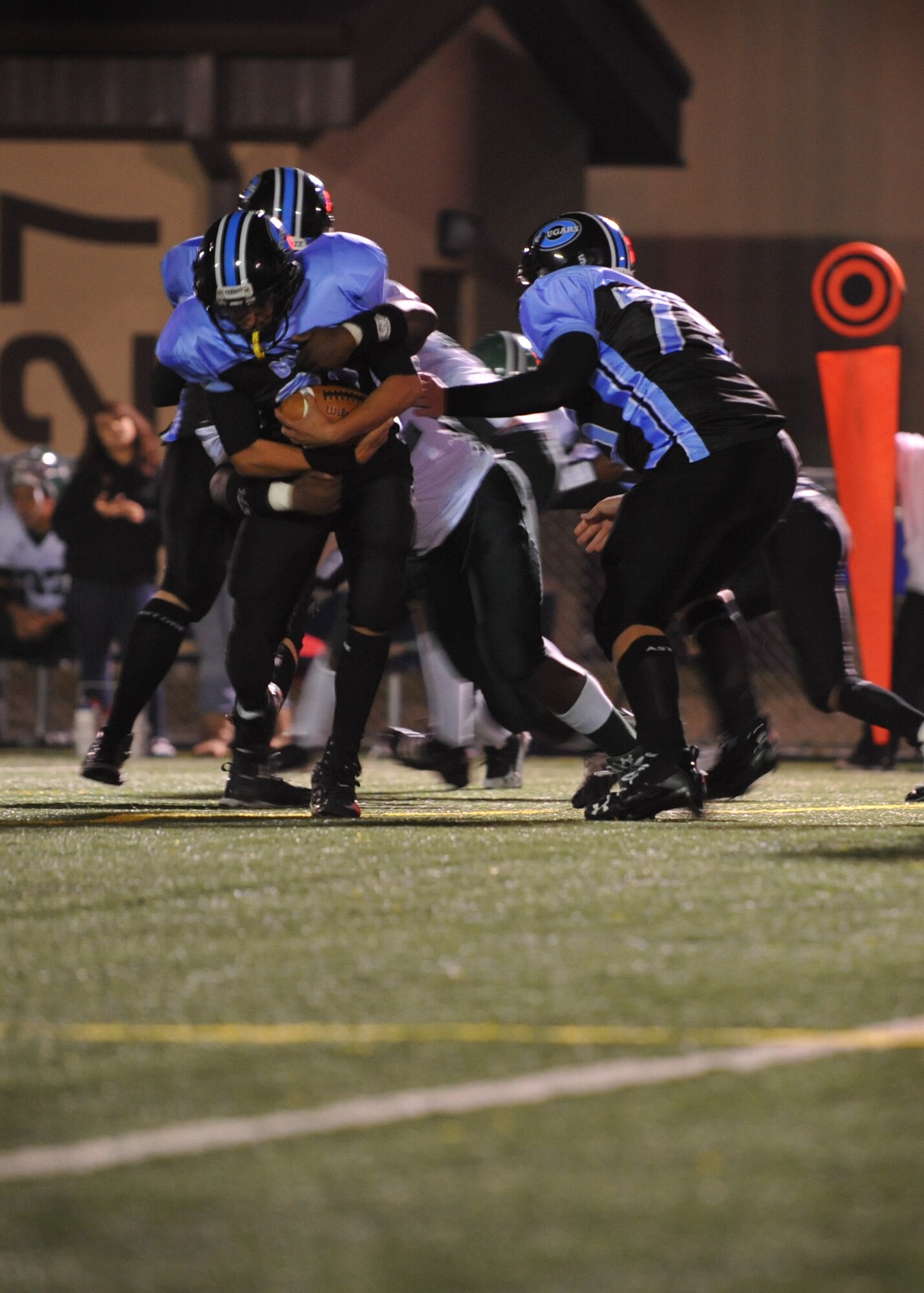 An Osan American High School football player gets tackled by a Daegu American High School defender Oct. 15 at Osan Air Base.  The OAHS Cougars fell short 28-6 but will host their final and homecoming game Oct. 29. (U.S. Air Force Photo/Senior Airman Evelyn Chavez)